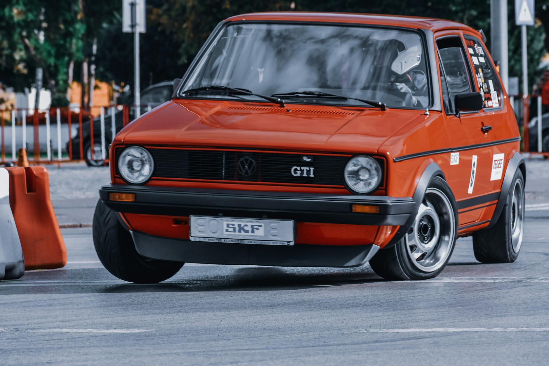 Czerwone sportowe GTI jedzie szybko po miejskim torze ulicznym