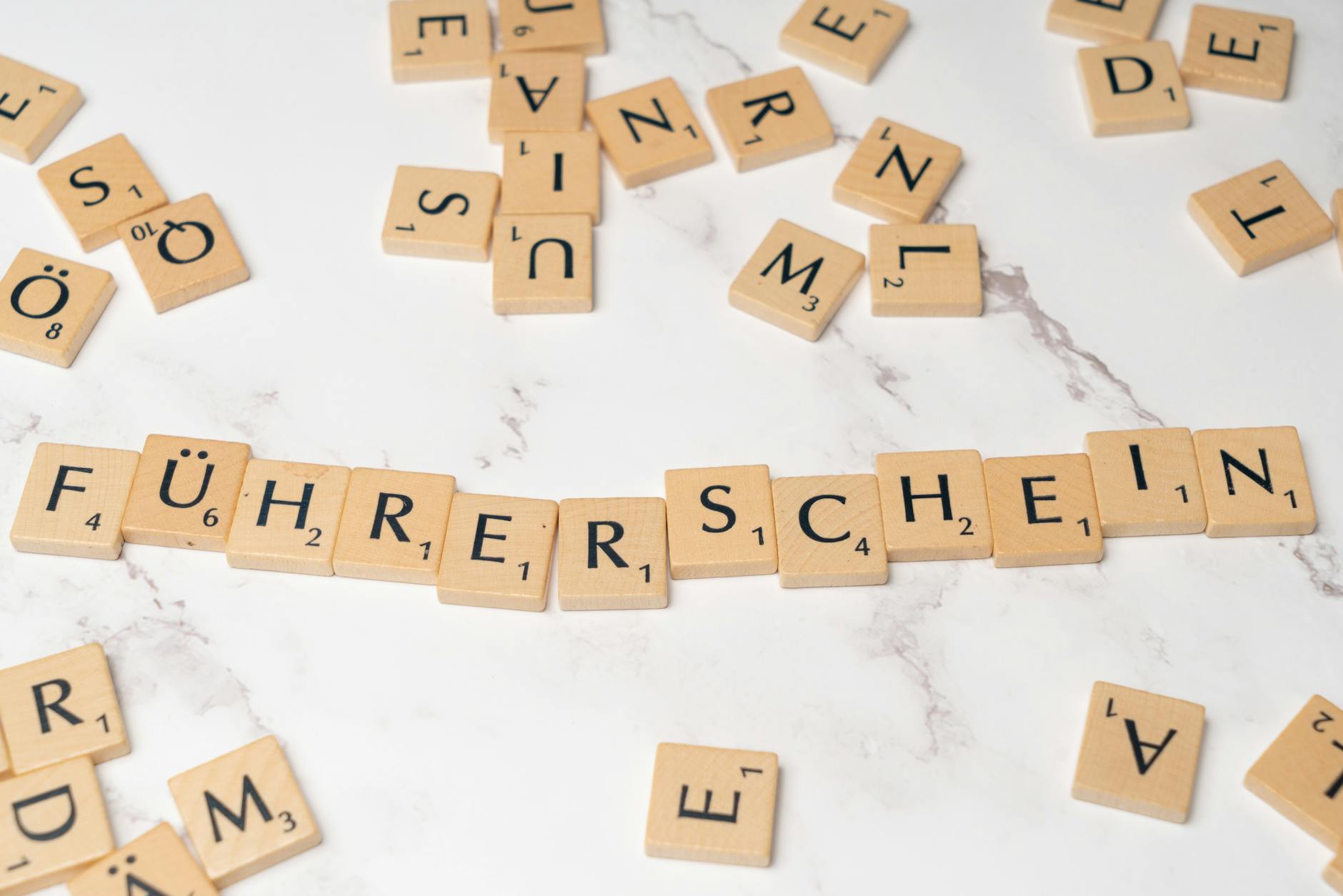 Kafelki scrabble układające się w słowo Führerschein na marmurze