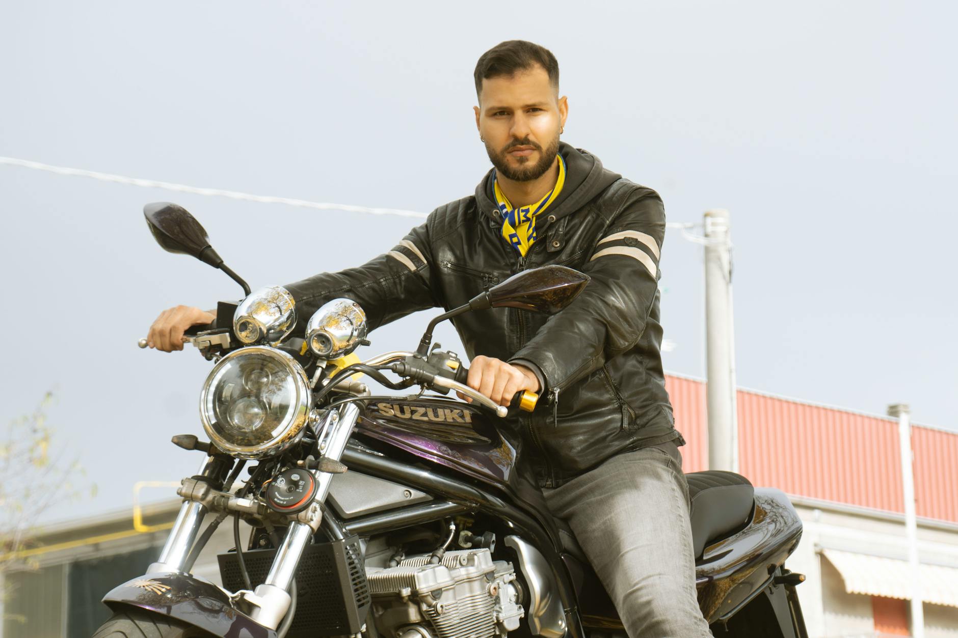 Mężczyzna siedzący na motocyklu Suzuki na ulicy w Maranello