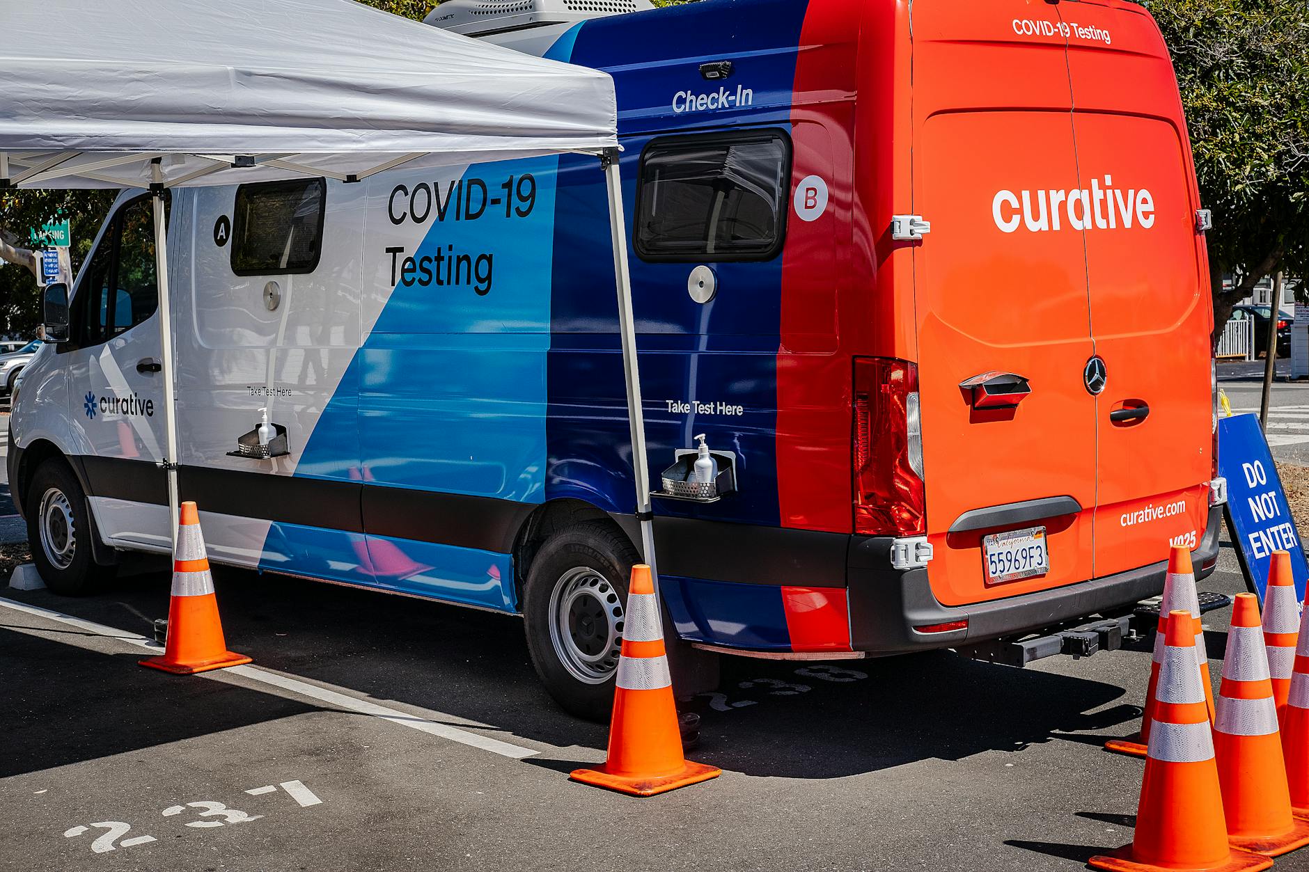 Mobilny punkt testów COVID-19 przy drodze z pachołkami i tablicą