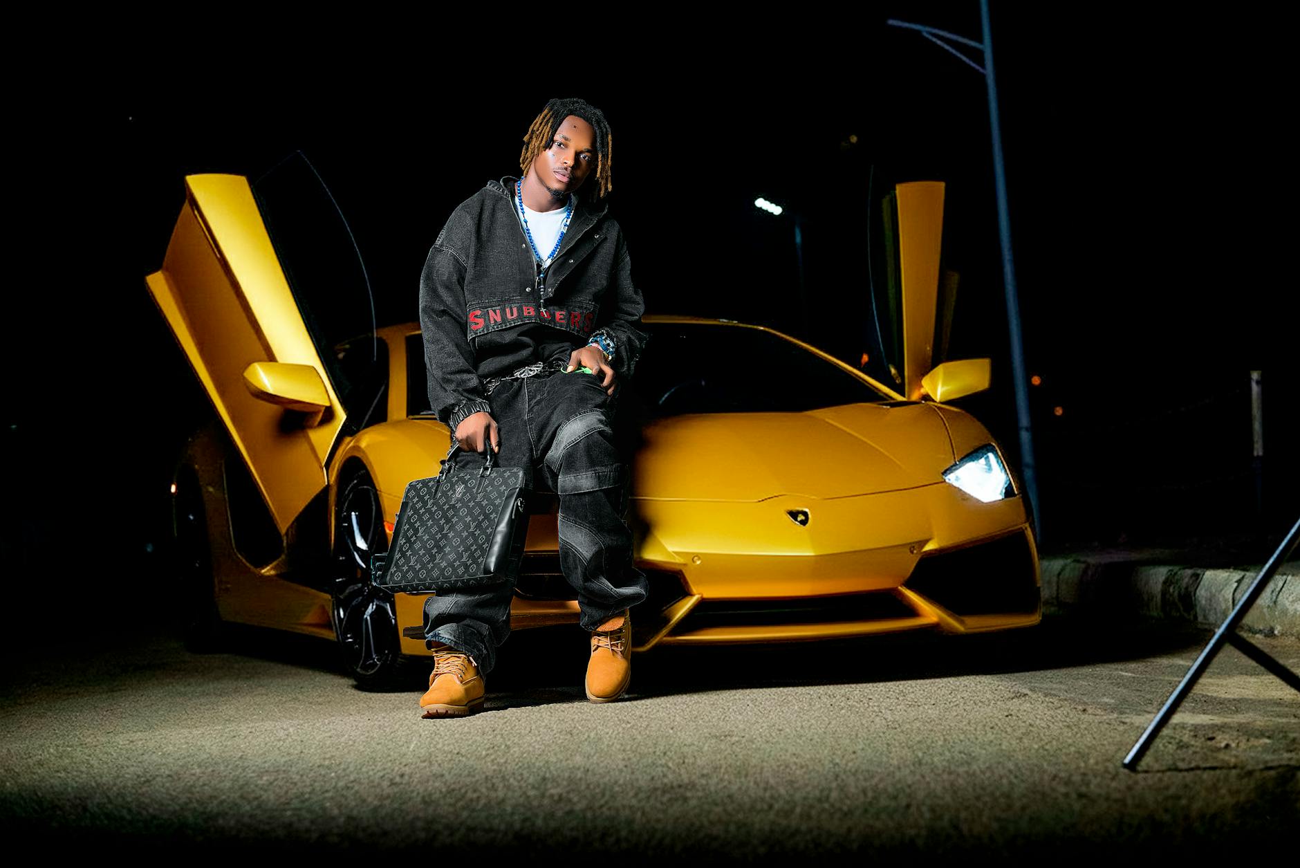 Osoba przy żółtym luksusowym aucie nocą na pustej ulicy