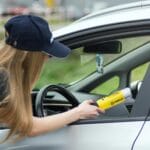 Policjantka sprawdza trzeźwość kierowcy alkomatem podczas kontroli