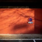 Znak parkingowy na pomarańczowej ścianie w mieście