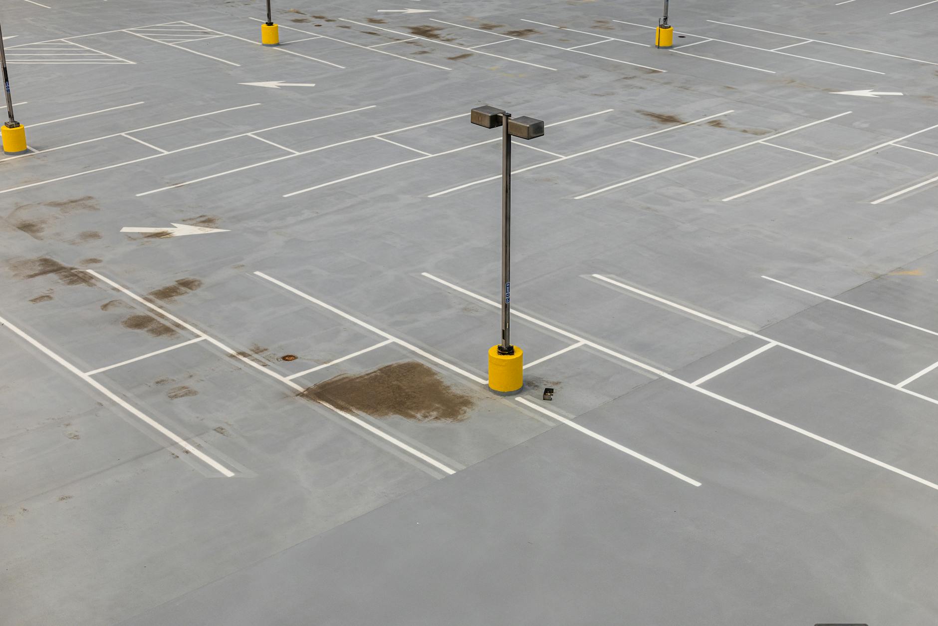 Pusty parking z białymi liniami i latarniami widziany z lotu ptaka