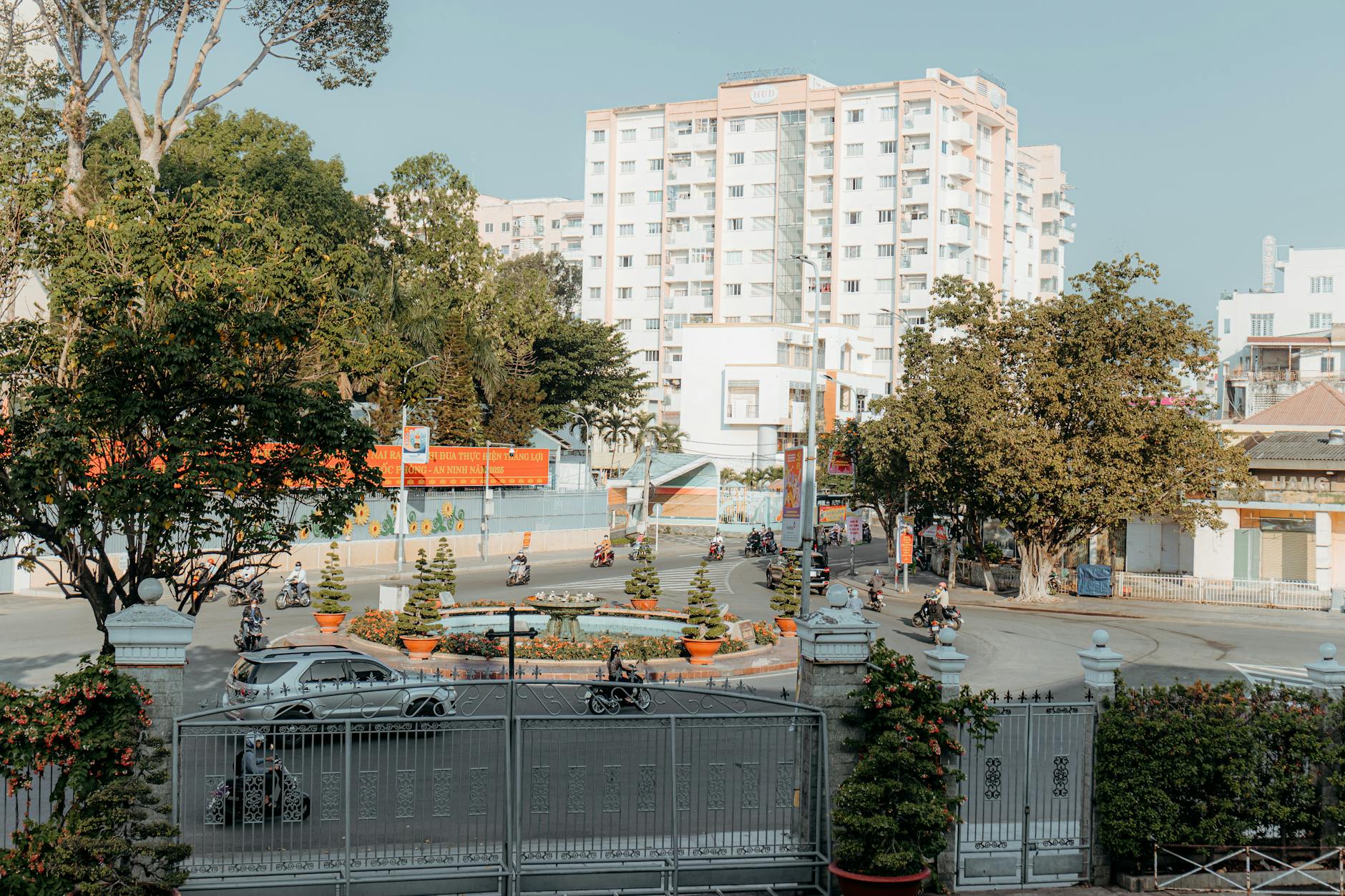 Rondo w centrum miasta otoczone wysokimi budynkami i zielenią