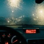 Jazdy w deszczu i na śliskiej nawierzchni: czego uczą na kursie, a co musisz przećwiczyć sam Widok z wnętrza auta na mokrą szybę i rozmyte nocne światła
