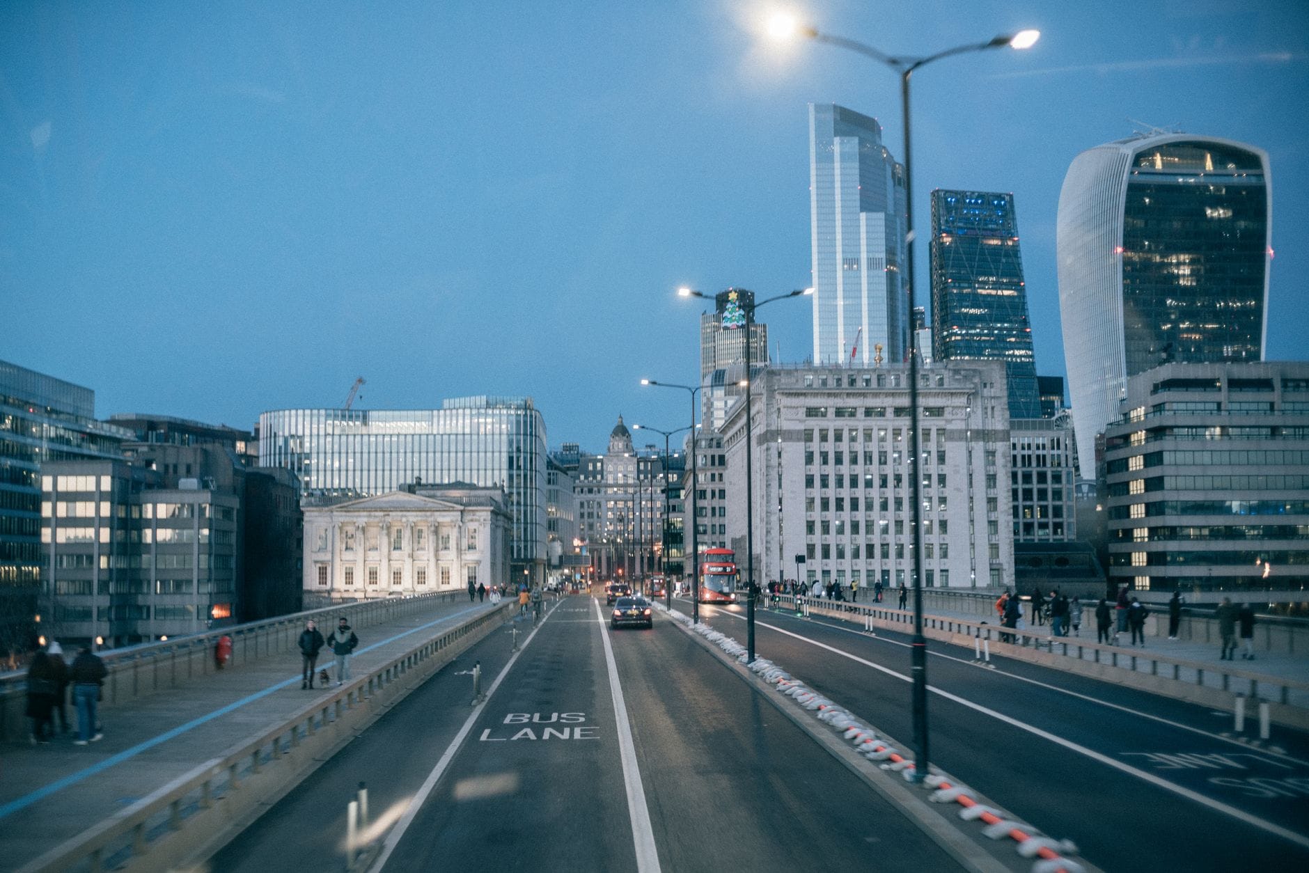 Wieczorny ruch uliczny na London Bridge na tle oświetlonych wieżowców