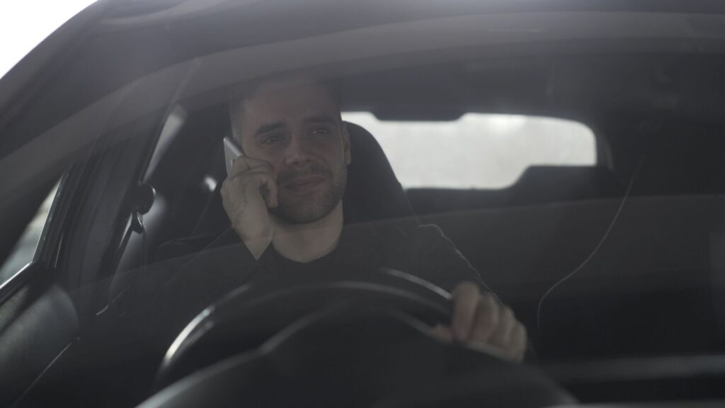 Mężczyzna rozmawia przez telefon podczas jazdy samochodem